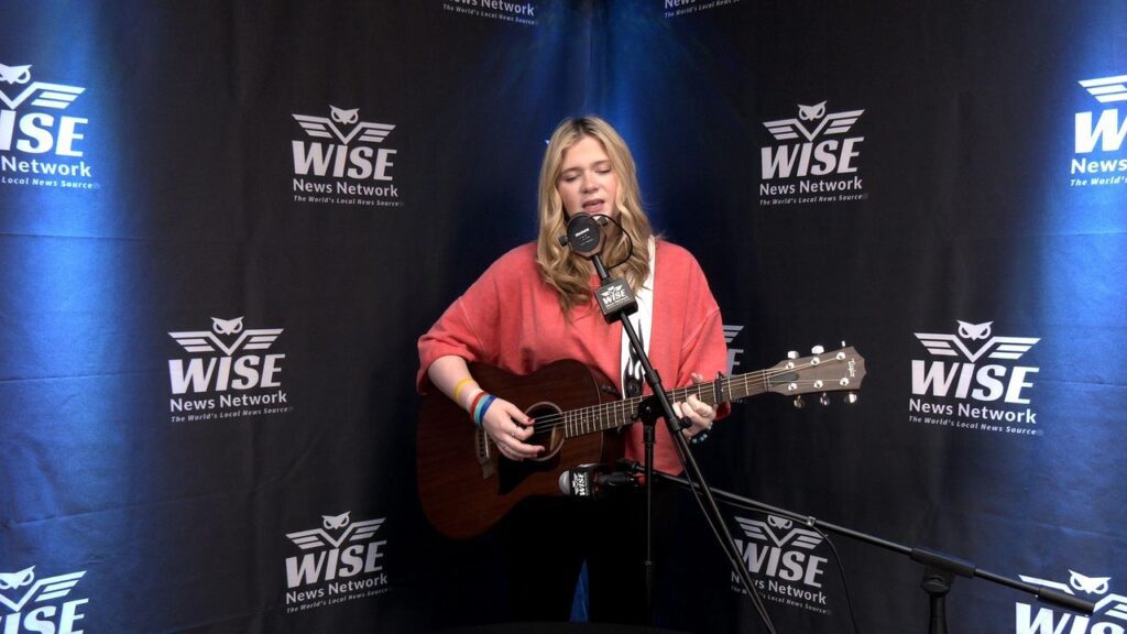 Bailey Marie Griggs singing and playing the guitar at the Wise News Network studio.