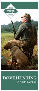 A man sitting in a chair with his dog.