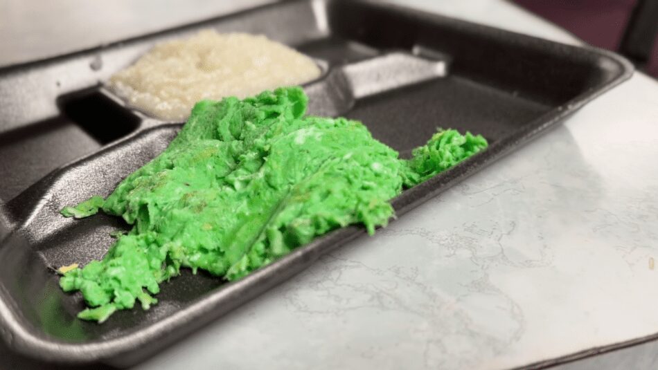 A plate with green eggs and grits.