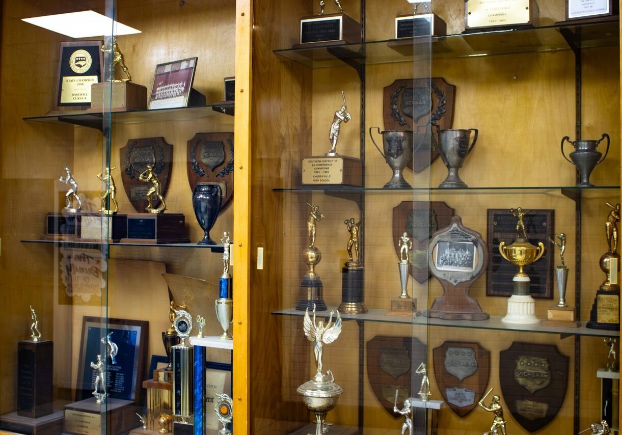 A display case with various trophies and awards arranged on multiple shelves.