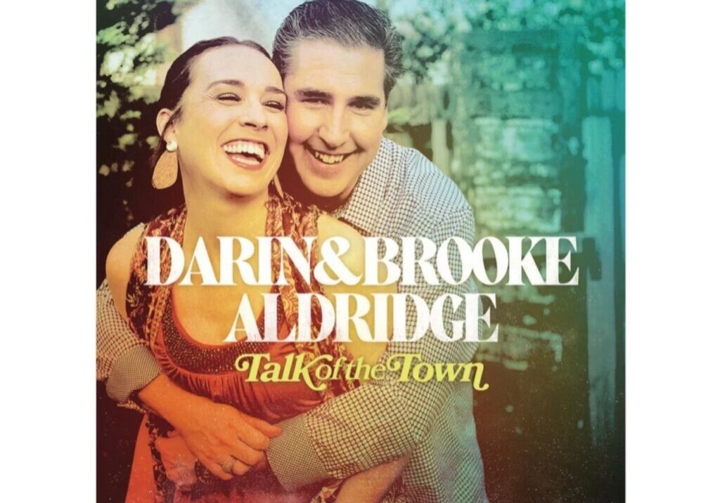 A smiling couple embraces on the cover of the album "Talk of the Town" by Darin and Brooke Aldridge.