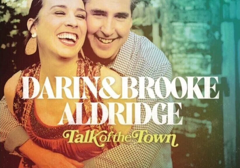 A smiling couple embraces on the cover of the album "Talk of the Town" by Darin and Brooke Aldridge.