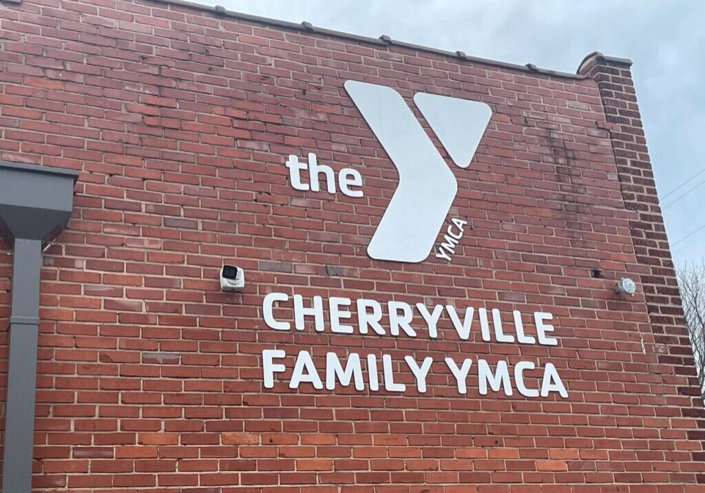 Exterior view of the Cherryville Family YMCA building with a brick wall and the YMCA logo and name prominently displayed.