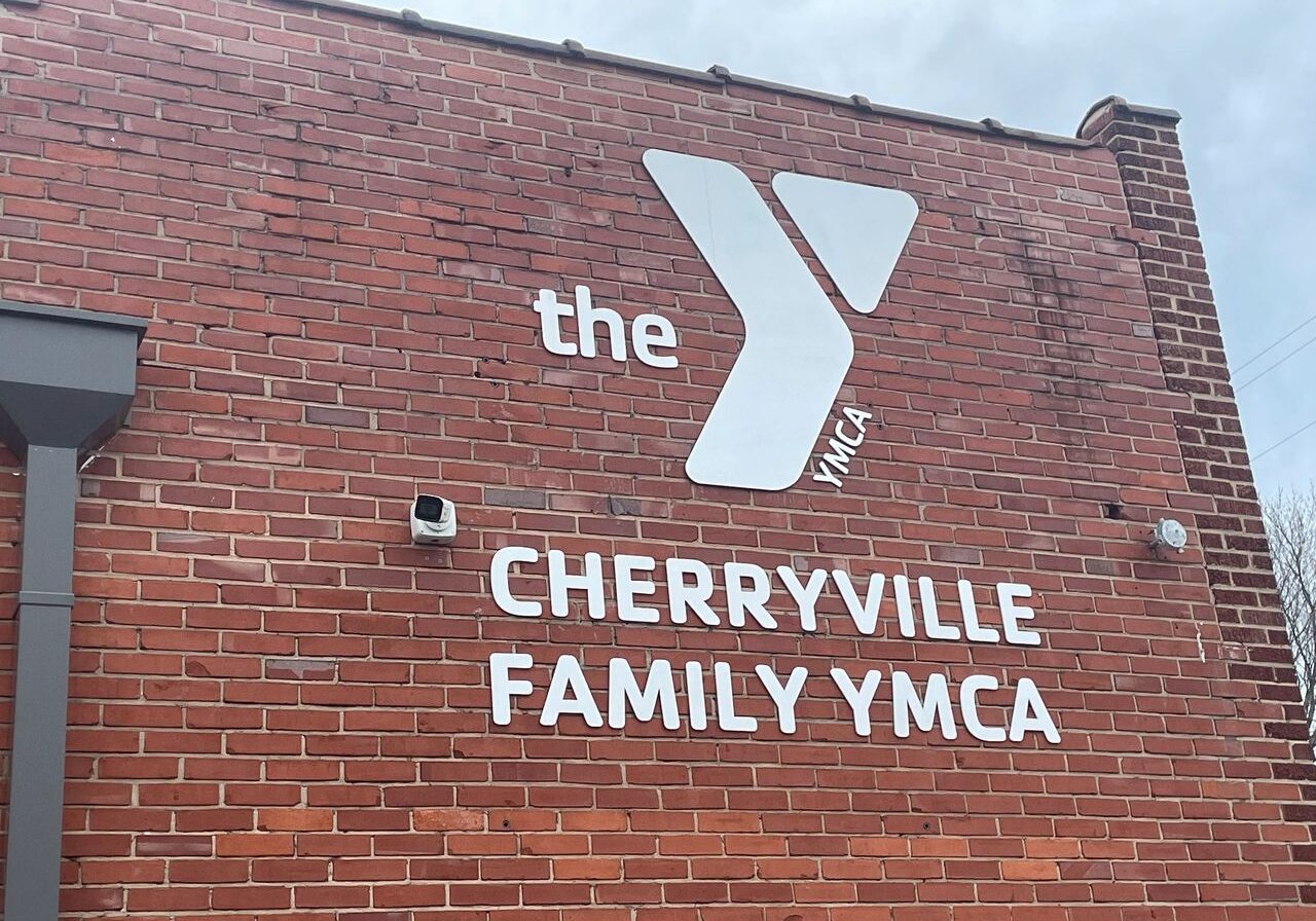 Exterior view of the Cherryville Family YMCA building with a brick wall and the YMCA logo and name prominently displayed.