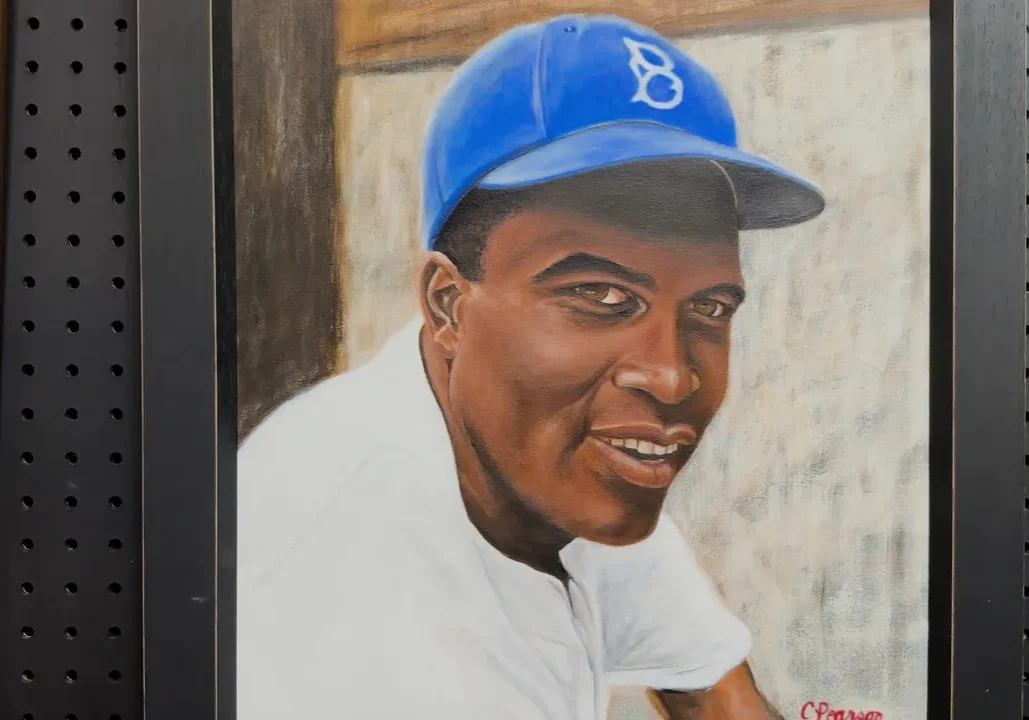 A painting of a baseball player in blue cap.