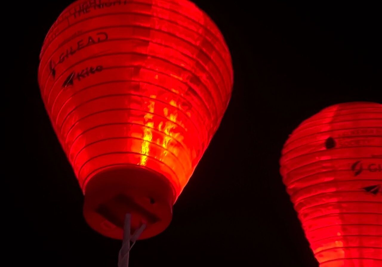 Two illuminated red lanterns against a dark background, with text and logos visible on their surfaces.