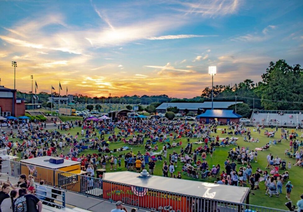 A crowd of people gathered in an open field.