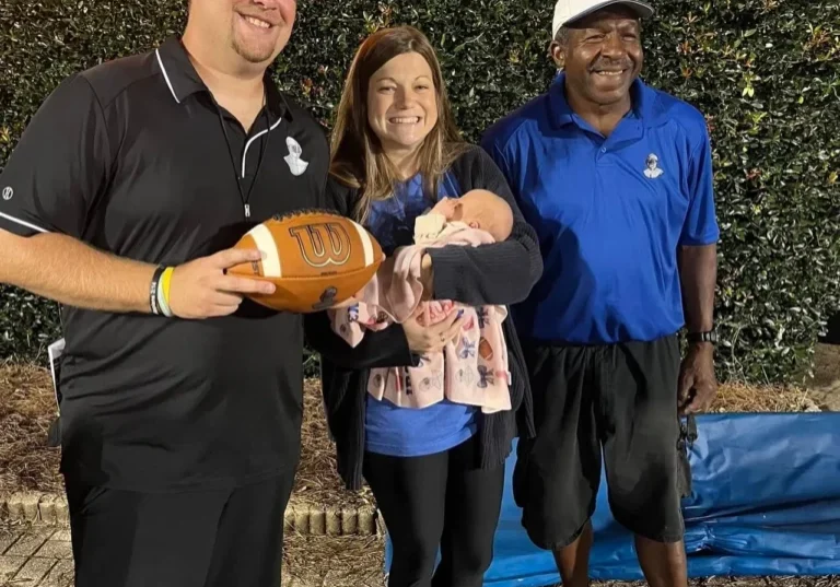 Ironmen Head Coach Patrick Bowman (L), his wife Sydney with newborn daughter (C), and Coach Lee Roy Montgomery (R) celebrating at Rudisill Stadium, Cherryville NC. August 23rd, 2024 (FB-Amy Harris Bowman Bailey)