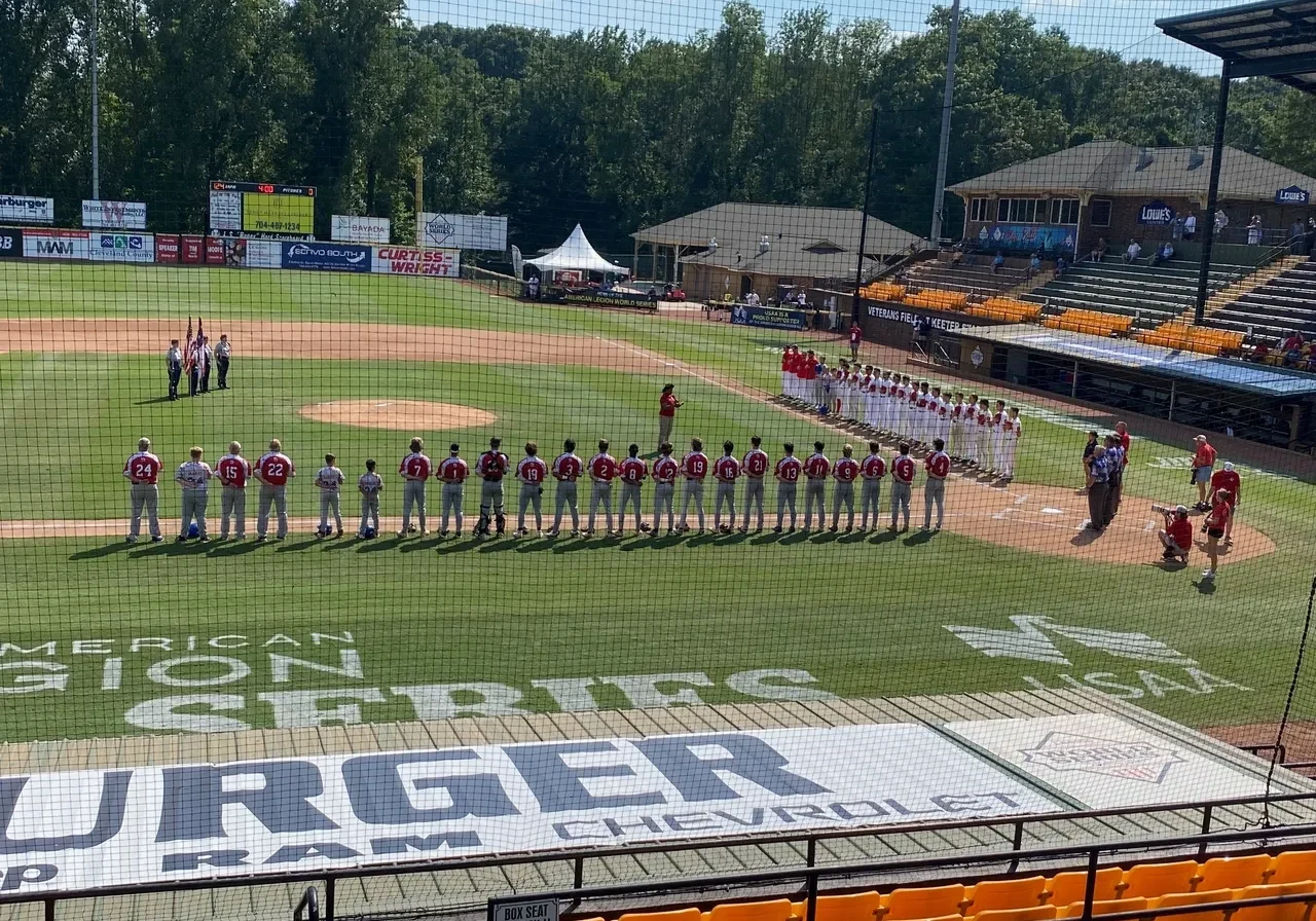 A baseball game with players lined up for the national anthem.